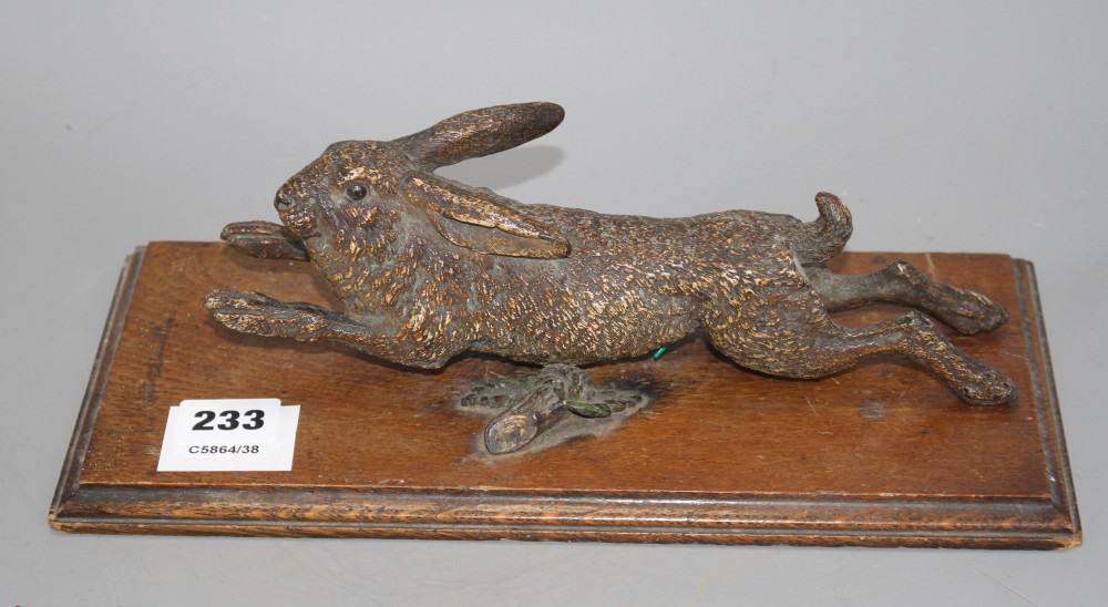 An Austrian cold painted door knocker modelled as a running hare, with oak mount, overall length 30cm, width 14cm, length of hare 25cm